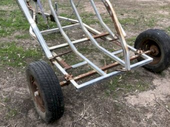 Round bale feed out trailer
