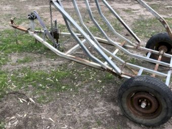 Round bale feed out trailer