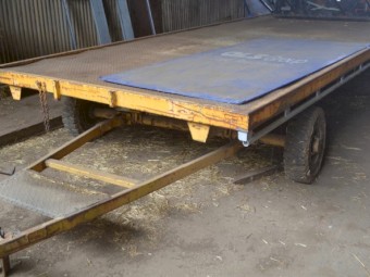 A large, HD steerable flatbed yard trailer
