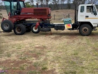 Case IH 8825HP Windrower with 25ft Case Draper Front &amp; side exit on a Leith Trailer